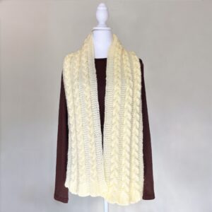 Handmade Cable Knit Off White Scarf draped on a white mannequin torso with a brown top, set against a neutral background, conveying warmth and coziness.